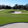 A view of a green surrounded by bunkers at Deer Island Country Club